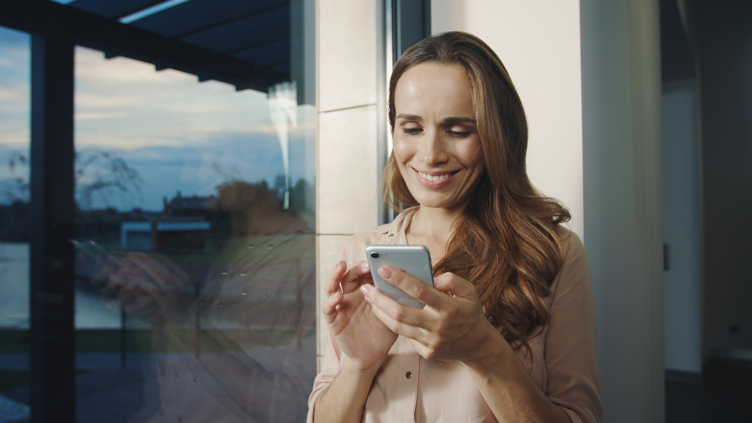 Happy Woman Looking Mobile Phone near. Smiling Woman Scrolling Smartphone.